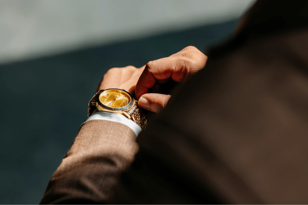 Man adjusting gold wristwatch