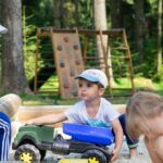 Alt text: Children playing outdoors with shovel.