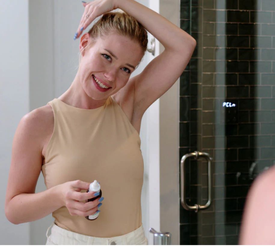 Woman applying cleanser in bathroom