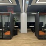 Two soundproof office privacy pods in a modern workspace