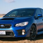 Vehicle speeding through dusty mountain road.